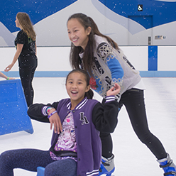 kids having fun ice skating with a skating aid