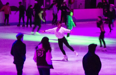 Girl practicing spins during an evening ice skating session
